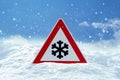 Traffic sign warns of snow and ice at road in winter Royalty Free Stock Photo