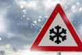 Traffic sign warns of snow and ice at road in winter Royalty Free Stock Photo