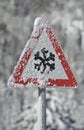 Traffic sign warns of snow and ice at winter on road Royalty Free Stock Photo