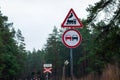 Traffic signs for railroad crossing, no overtaking and stop sign Stop written in Russian against forest trees Royalty Free Stock Photo