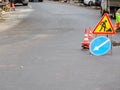 Traffic signs and stacked traffic cones stand on the road where repair work is underway Royalty Free Stock Photo