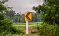 Traffic signs tell the curve on the side of the rural road. Royalty Free Stock Photo