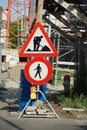 Traffic signs of work on the road and no entry on a construction site.