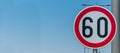 Traffic speed limit sign for restriction on 60 kilometers or miles per hour with blue sky background with copy space Royalty Free Stock Photo