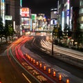 Traffic streams down a Tokyo street full of Neon Signs