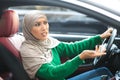 Angry muslim woman in hijab driving her car and arguing