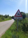 a traffic warning sign for deer crossing the road, in a rural area