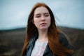 A tragic portrait of a young woman with long red hair. Royalty Free Stock Photo