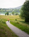 Young woman running along curved path around Tegernsee Lake. Royalty Free Stock Photo