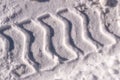 Trail of a large wheeled tractor in the snow