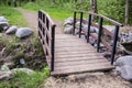 Trail leads to a small wooden bridge over the creek shore is lin Royalty Free Stock Photo