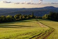 Walking trail in meadow of rolling hills landscape Rhoen in fall by sunset