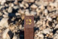 Trail Mile Marker Number Thirteen (13) carved on a wooden post and painted yellow Royalty Free Stock Photo