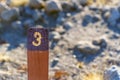 Trail Mile Marker Number Three (3) carved on a wooden post and painted yellow Royalty Free Stock Photo