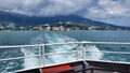 The trail of a pleasure boat on the sea, the coast of the resort city of Yalta, stretching into the distance on a cloudy