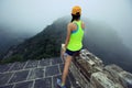 Trail runner haves a rest at great wall on the top of mountain