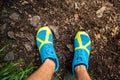 Trail runner looking down at sports shoe, running in nature
