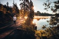 Trail runner in wild nature by lake, gold morning light in background