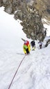 Runners at a mountain race climbing on a rope 