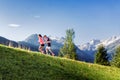Trail runners running and training in the hills and mountains of the Alps in Europe, running towards a steep and snowy mountain Royalty Free Stock Photo