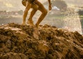 Trail running athlete crossing the dirty puddle in a mud racer