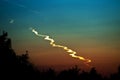 Trail smoke of a fallen asteroid meteor at after sunset in the forest.