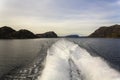 Trail on water of fast moving boat with mountains and Norway fjord landscape Royalty Free Stock Photo