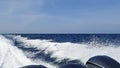 Sea wake trail behind a speed boat with waves, foam, bubbles on the ocean water surface with clear bright blue sky Royalty Free Stock Photo