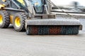 The compact road grader removes dirt from the road with a hydraulic nylon brush. Copy space