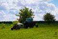 Trailed old harrow with agricultural tractor against the background of green field on an summer day. Rural landscape Royalty Free Stock Photo