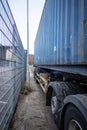 Trailer with freight container parked close to a fence and pole.. Royalty Free Stock Photo