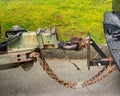 A trailer hitch with a rusting chain being used to join two vehicles together