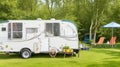 Trailer of mobile home stands in garden in camp... Royalty Free Stock Photo