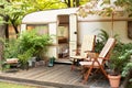 Trailer of mobile home stands in garden in camping. Backyard with RV house with garden furniture. Royalty Free Stock Photo