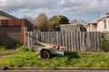 Trailer with some household rubbish sits on the footpath of a suburban house