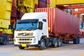 Trailer truck loaded with forty feet container under quay crane.