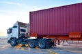 Trailer truck loaded with forty feet container under quay crane.