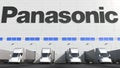 Electric semi-trailer trucks at warehouse loading bay with PANASONIC logo on the wall. Editorial 3D rendering