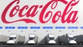 Electric semi-trailer trucks at warehouse loading bay with COCA-COLA logo on the wall. Editorial 3D rendering Royalty Free Stock Photo