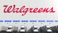 Electric trailer trucks at warehouse loading bay with WALGREENS logo on the wall. Editorial 3D rendering Royalty Free Stock Photo