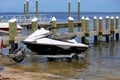 trailer with jet ski disembarking on the shore of a jetty