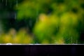 Trails of falling raindrops on the edge of a fence with a long exposure, abstract background