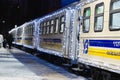 Train arrived at the station. The train cars decorated with Christmas garlands near the station platform