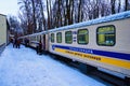 The train cars decorated with Christmas garlands near the station platform. Train arrived at the station.