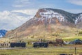 Train cars on track in front of houses in Silverton Colorado with mountains with snow in background Royalty Free Stock Photo