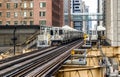 Train on elevated tracks within buildings at the Loop, Glass and Steel bridge between buildings - Chicago City Center - Chicago, I Royalty Free Stock Photo