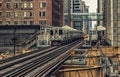 Train on elevated tracks within buildings at the Loop, Glass and Steel bridge between buildings - Chicago City Center - Dark Cross Royalty Free Stock Photo