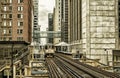 Train on elevated tracks within buildings at the Loop, Glass and Steel bridge between buildings - Chicago City Center - Black Gold Royalty Free Stock Photo