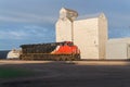 Train engine parked in front of old grain elevators Royalty Free Stock Photo