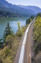 The train goes by rail road along the gorgeous Columbia River with mountains covered with forests at Columbia Gorge Royalty Free Stock Photo